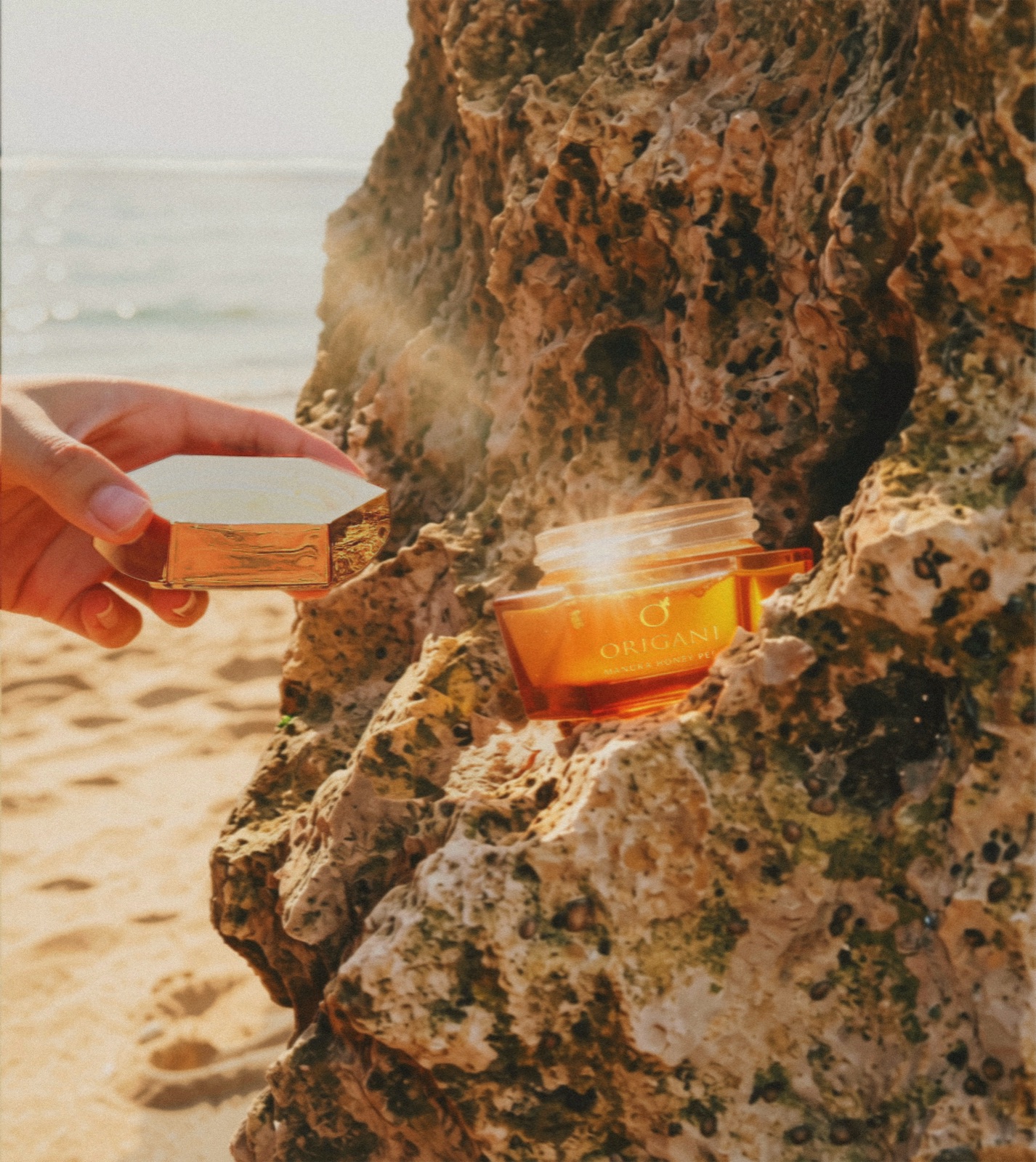 Skincare jar photographed on a beach rock at golden hour